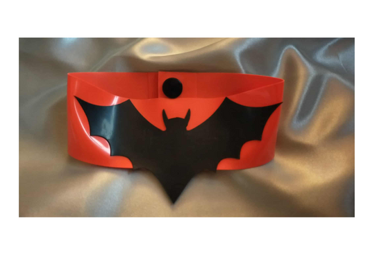 Red and black bat-shaped choker on a textured surface