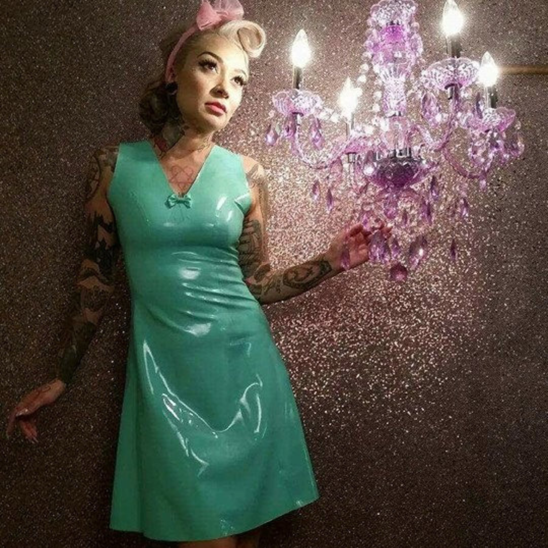 A jade green latex dress with bow detail on the V neckline.
