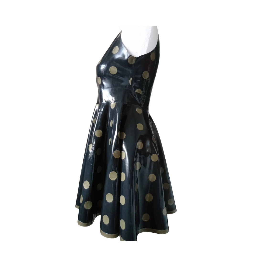 A black sleeveless fit and flare dress with gold polka dots. It has a matching gold trim on the hemline.