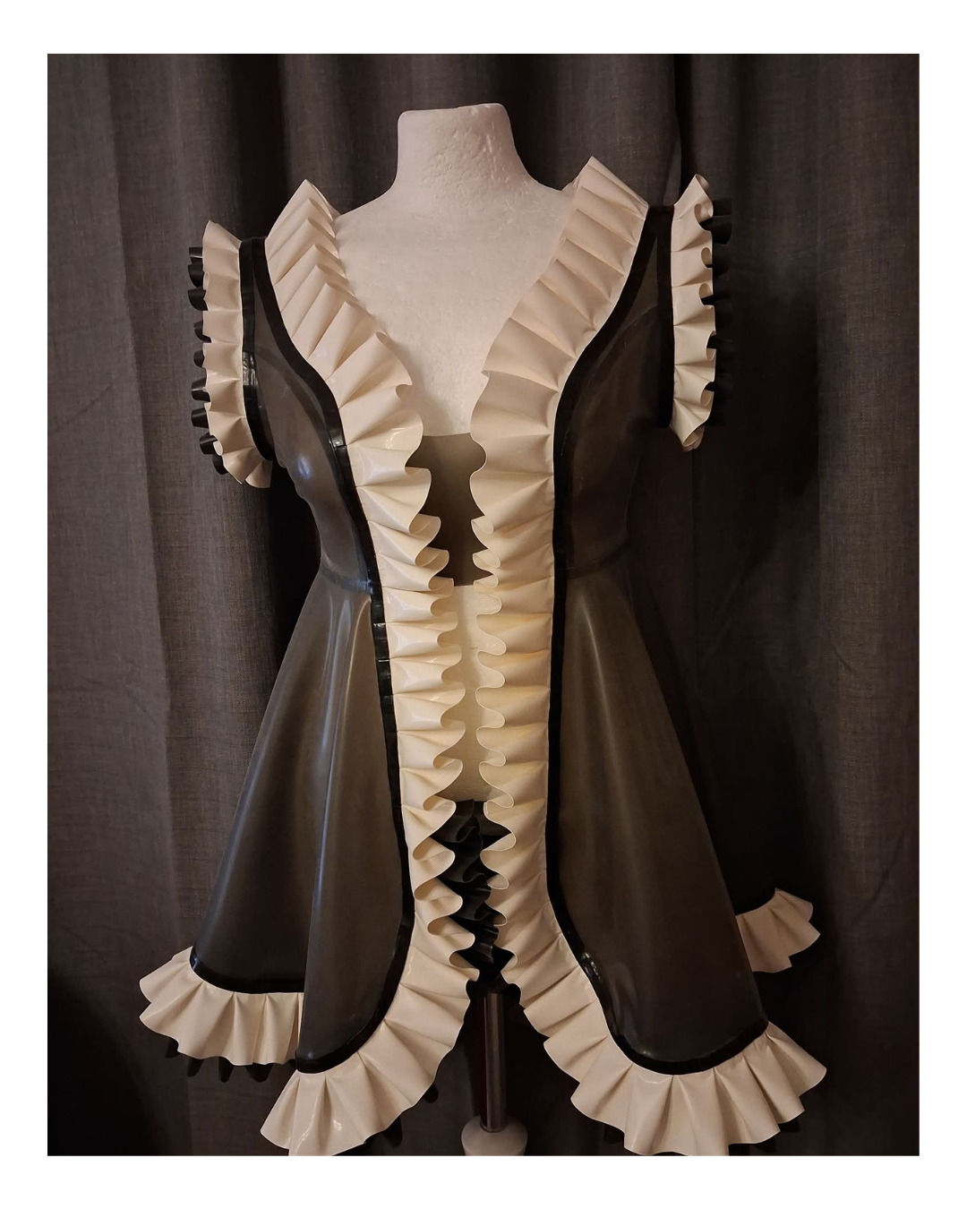 Vintage-style latex night with ruffled details on a mannequin against a dark curtain background
