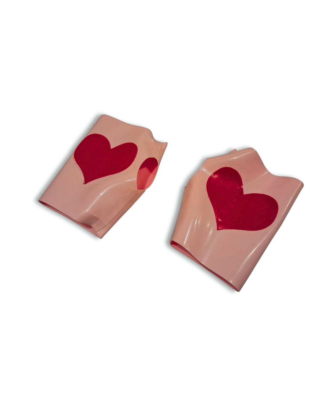 Two pink fingerless gloves with red heart designs on a white background