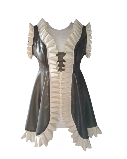 A short latex nightie with translucent smoky black bodice and structured white frilled trim, displayed on a mannequin. The dress features an open front with a modesty panel and bold 2‑inch ruffles along the edges