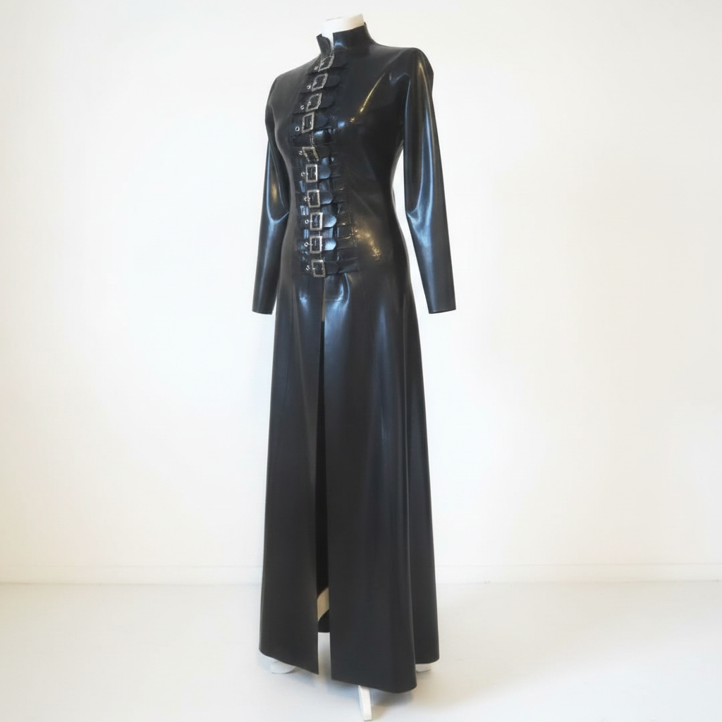 A long black latex coat with a high mock neck, long sleeves, and a front slit, decorated with a vertical row of silver buckle details down the chest, displayed on a mannequin against a plain white background.