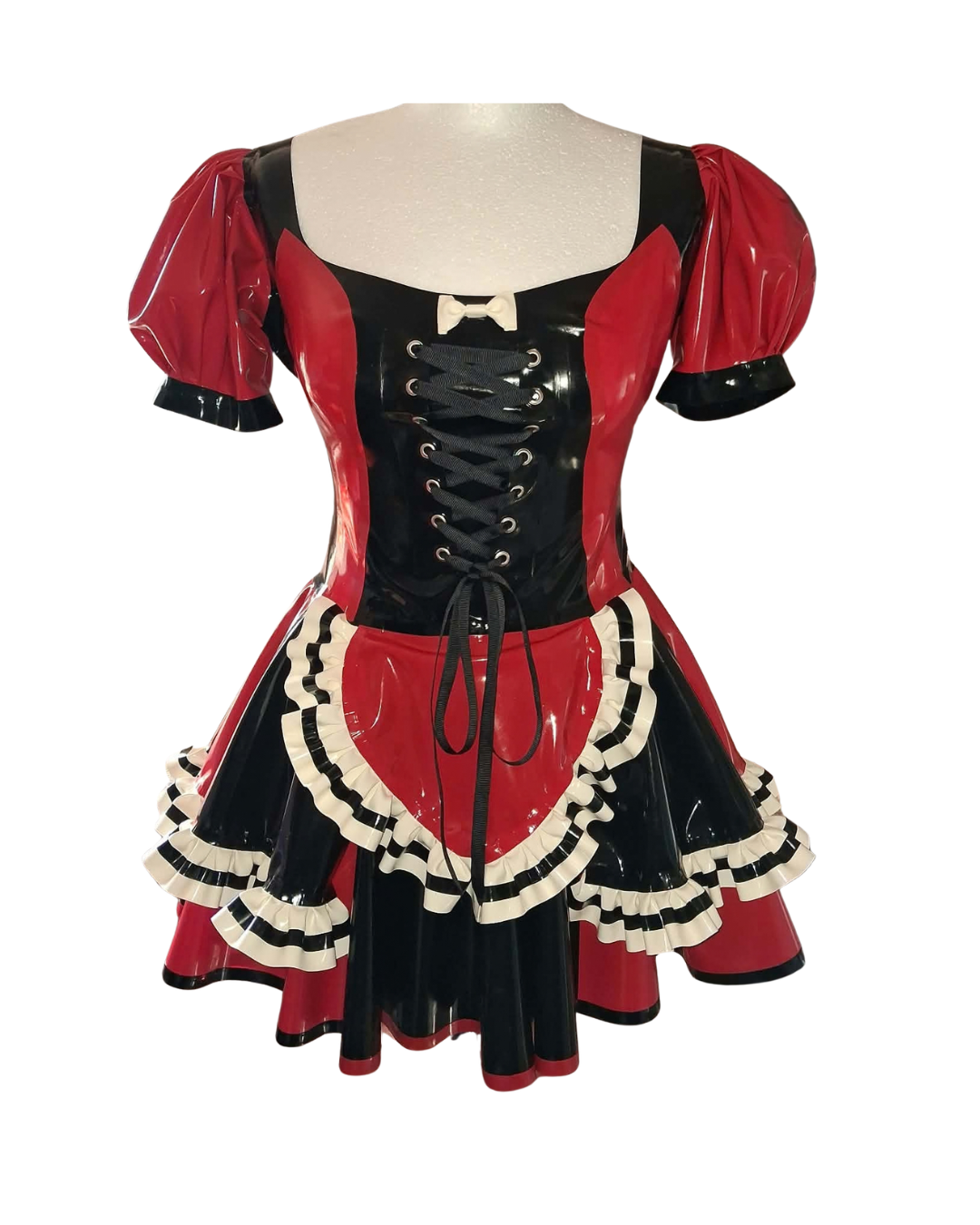 A red and black latex dress with black lacing. Frill and black frilled apron against a white background.