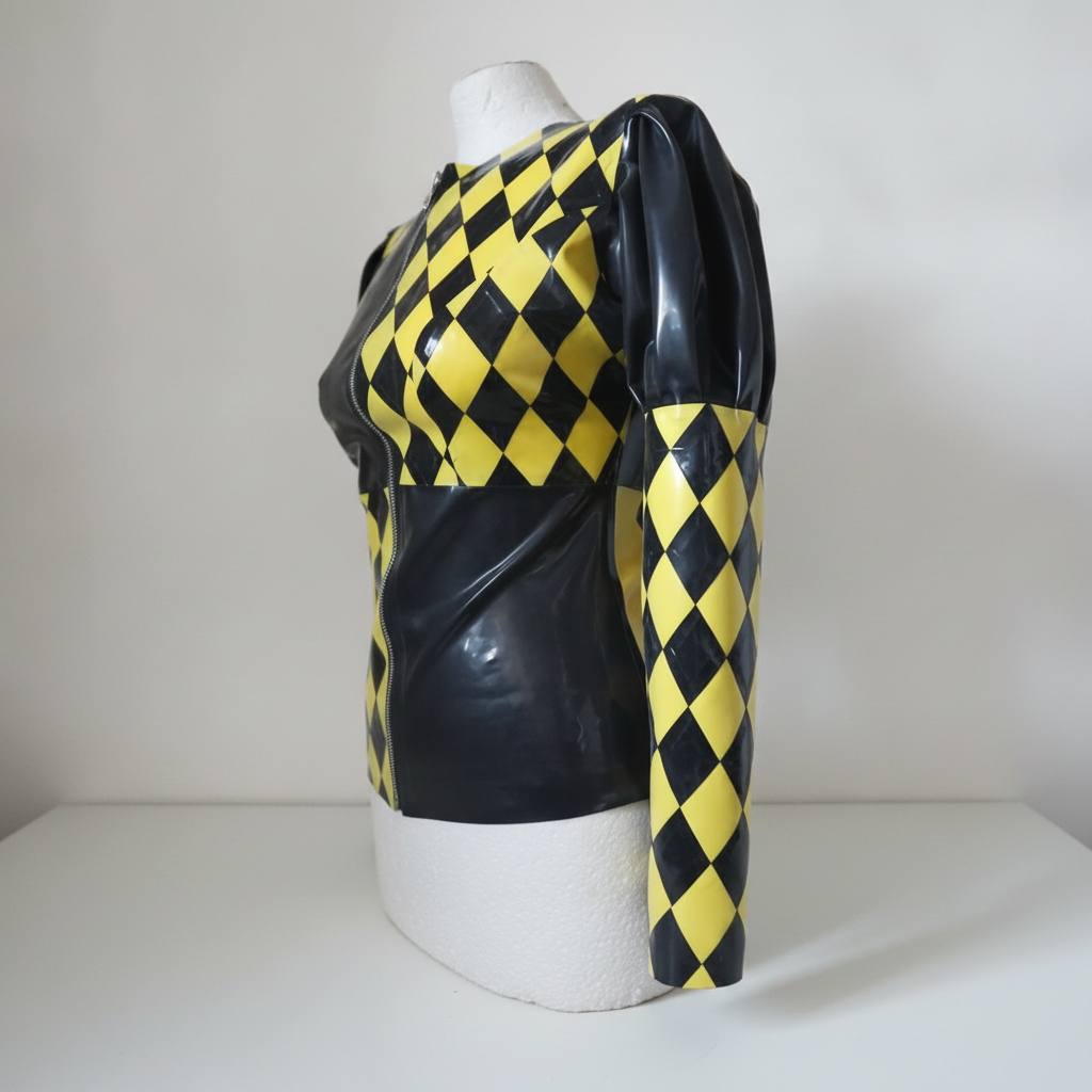 A long-sleeve latex top with a yellow and black harlequin diamond pattern, displayed on a white mannequin torso against a neutral light gray background.